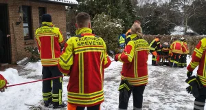 Feuerwehr Ramelsloh meistert heiklen Patienten-Transport auf Glatteis Mit Split und Arbeitsleinen sicherten die Feuerwehrleute die Fahrtrage auf dem gefährlich glatten Abhang. Foto: Clemens Cohrs, FF Ramelsloh